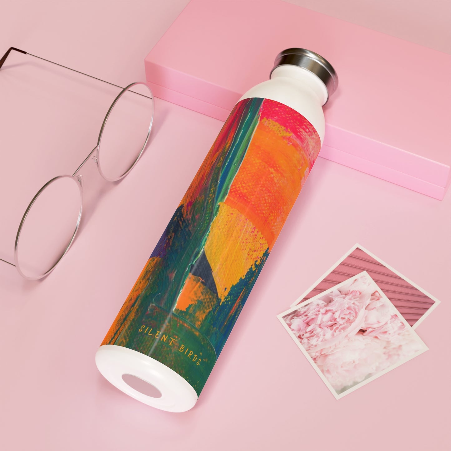 Colorful water bottle with a gradient design on a pink background