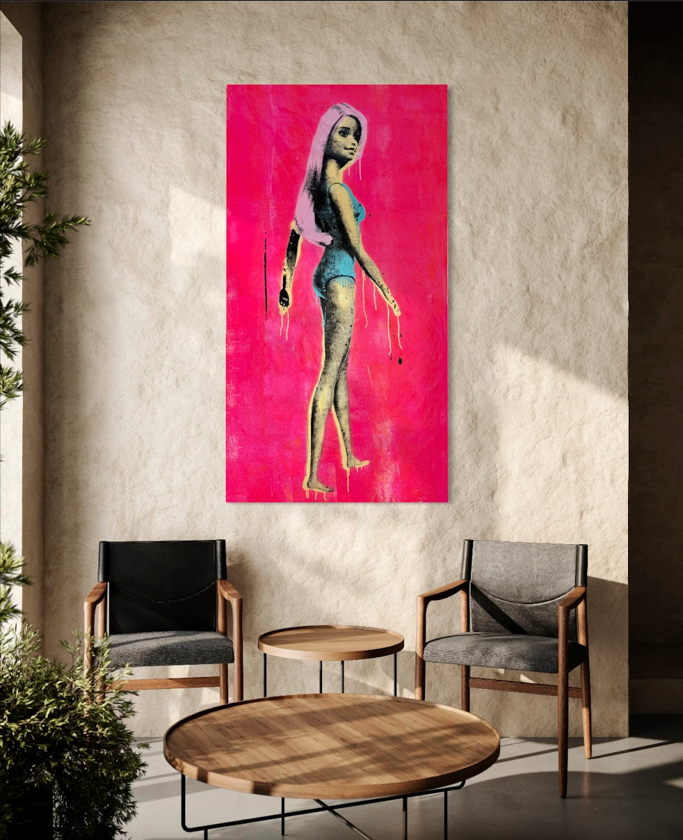 A vertical canvas art print featuring a stylized figure with pink hair against a vivid pink background, displayed on a textured beige wall in a modern living room setting with two armchairs and a round wooden coffee table. Barbie on Pink - Silk Screen, Acrylic & Spray Paint on canvas, 2024