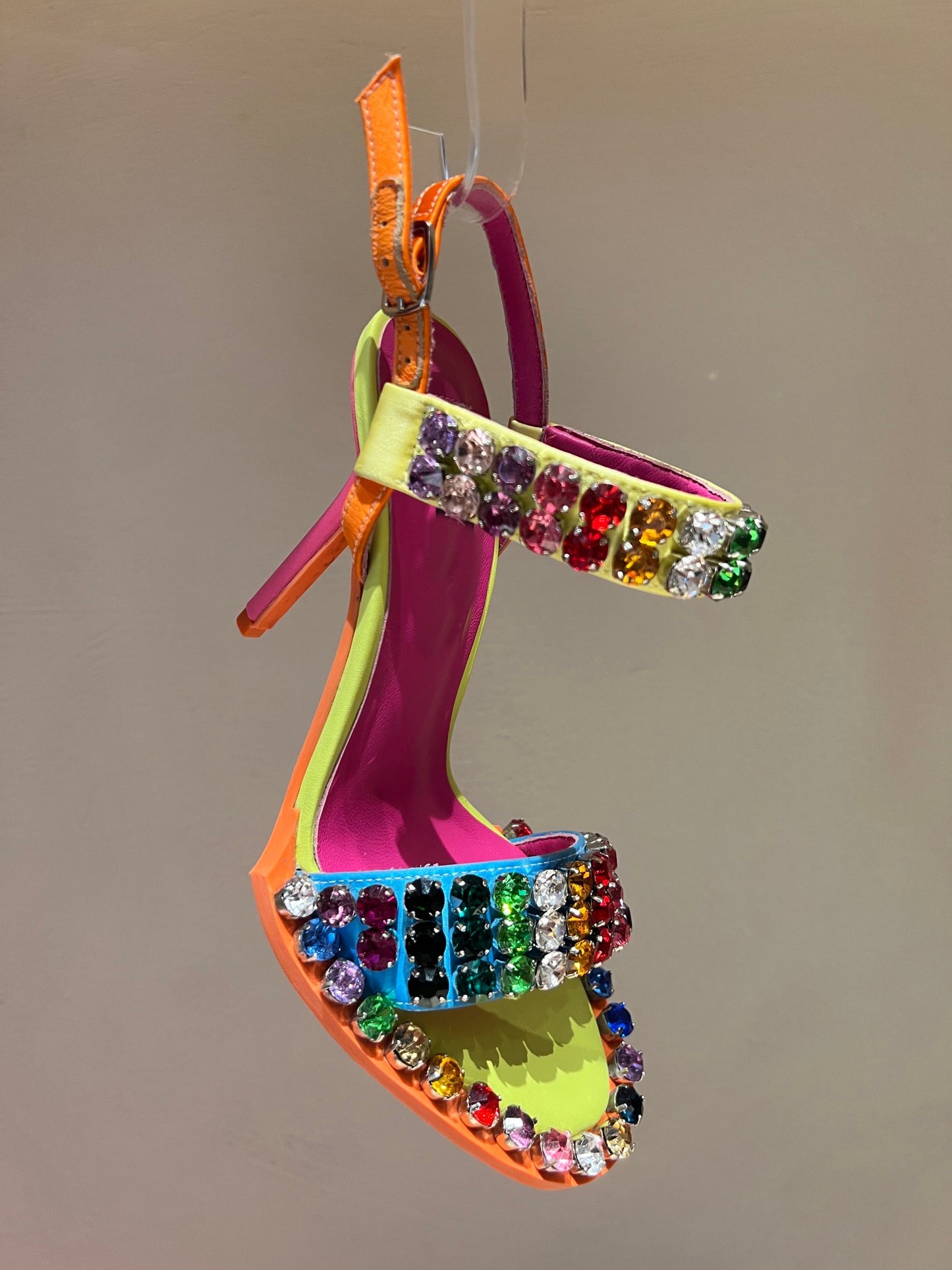 Colorful rhinestone ankle strap high heel sandal with rainbow crystal embellishments, neon pink and orange accents, open toe design, women's dress shoe side profile.