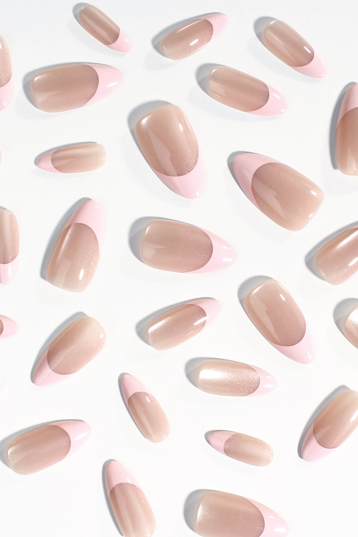 Close-up shot of Ballet Quartz press-on nails featuring a delicate beige cat-eye base and soft pink tips, displayed elegantly against a clean white background.