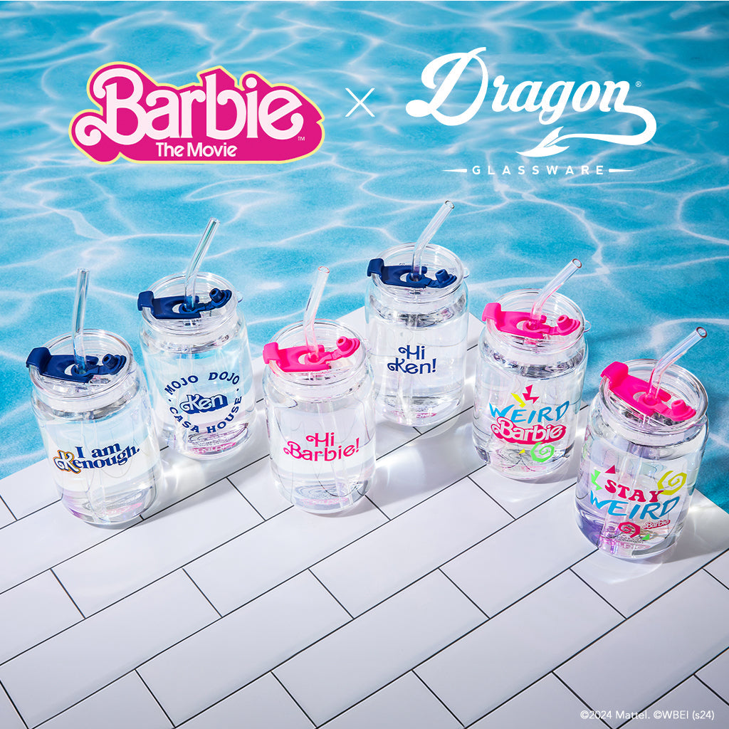 Set of clear tumblers with colorful text and designs on a tiled poolside background, featuring Barbie branding.