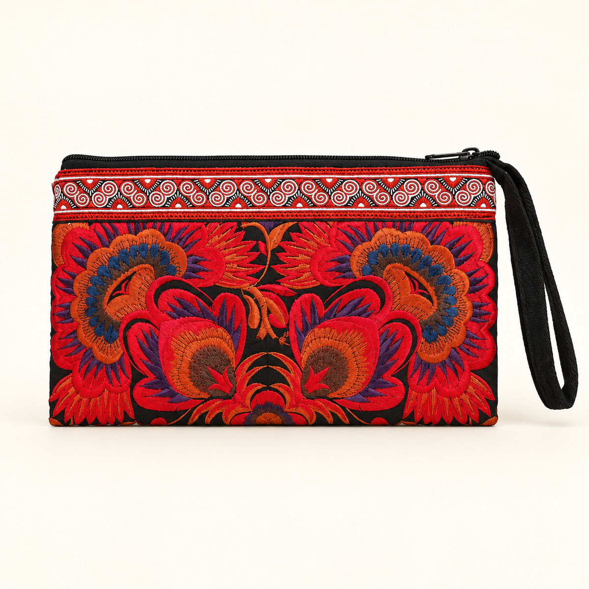 A rectangular wristlet clutch with a black base and vibrant red, orange, and blue floral embroidery, featuring a patterned red and white border and a black wrist strap, shown against a plain off-white background.