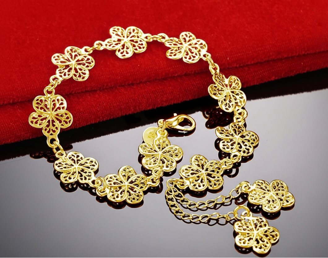 Gold bracelet with floral designs on a red and black background