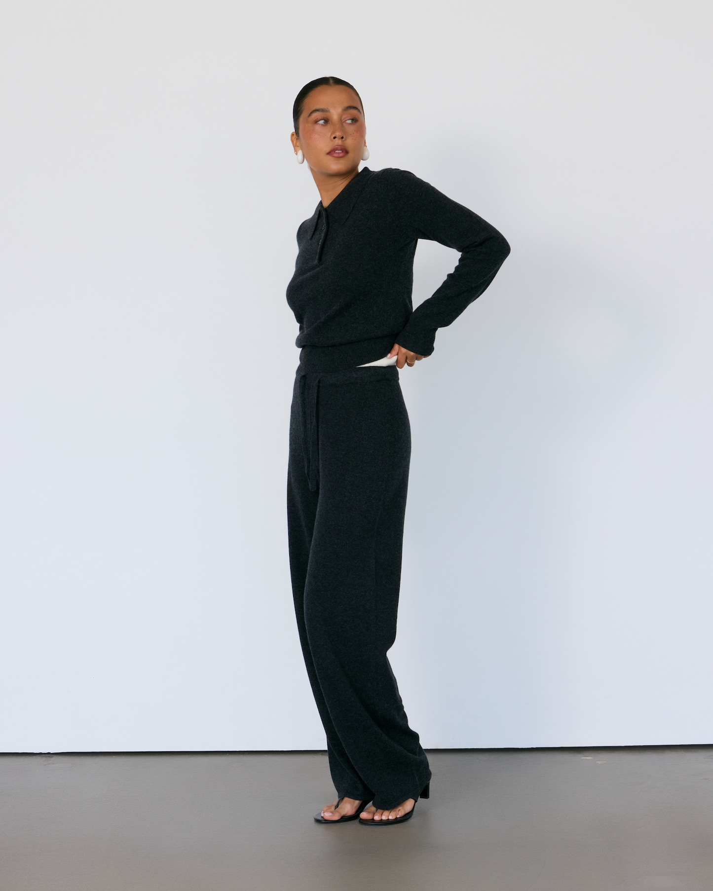 Person wearing a black cashmere outfit against a white background