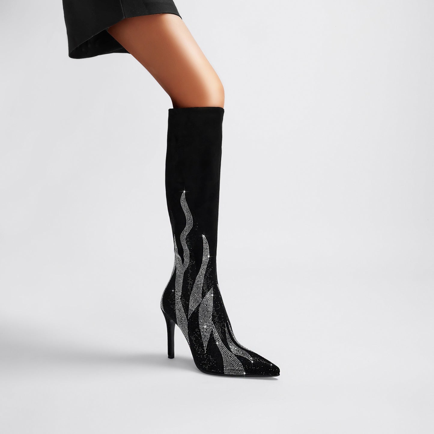Black knee-high pointed-toe stiletto boots featuring sparkling silver flame rhinestone embellishments, a sleek stretch shaft, side zipper closure, and slim stiletto heels, photographed on a white background.