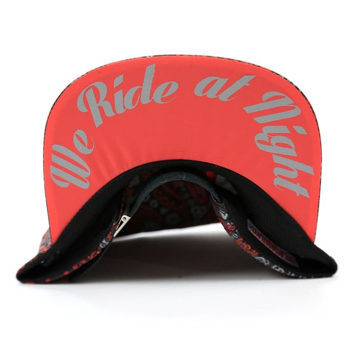 A red motorcycle helmet visor with 'We Ride at Night' printed in white script across the front, shown on a white background.