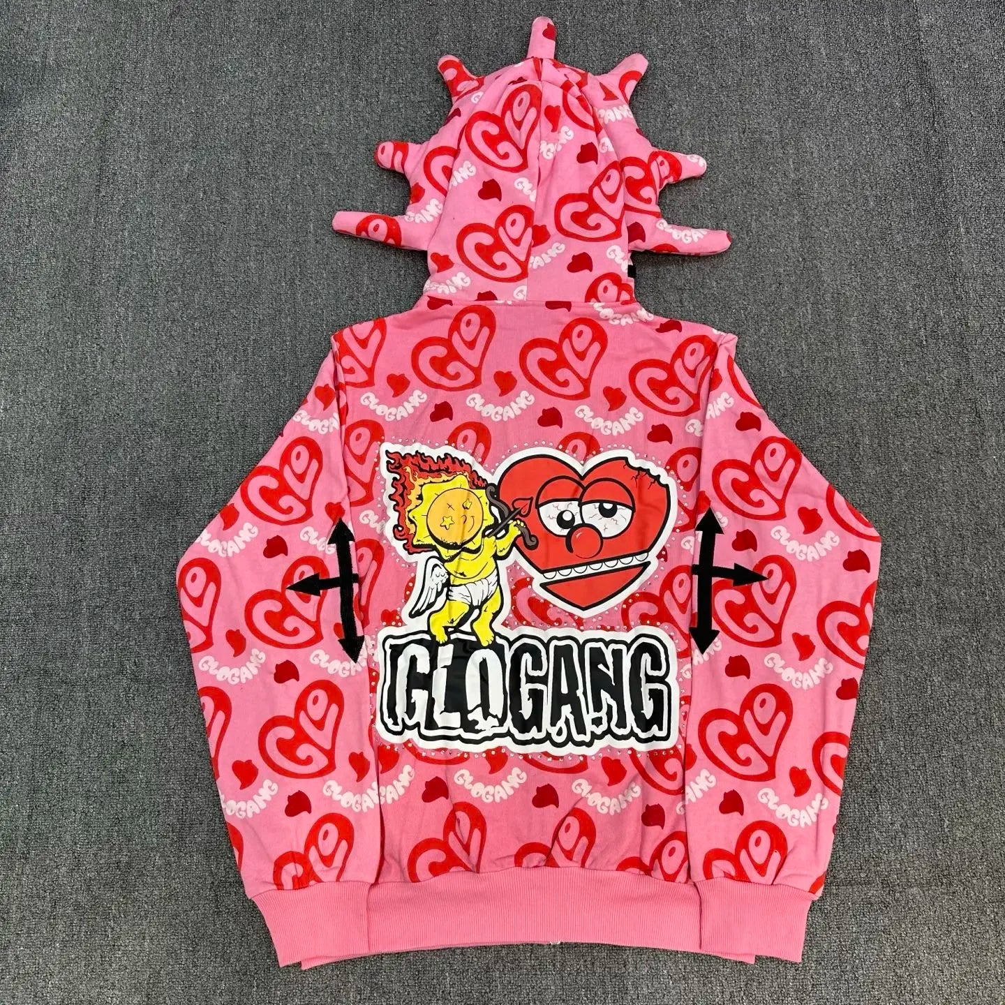 Pink hoodie with heart patterns and a graphic design on a gray background