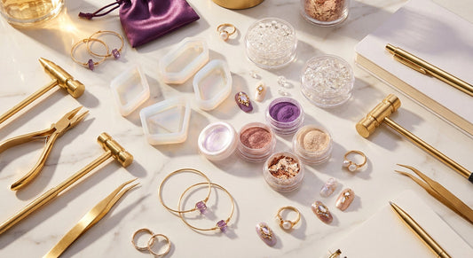A luxurious flat lay of gold jewelry-making tools, resin molds, crystal beads, and nail art supplies arranged artfully on white marble with warm golden lighting.