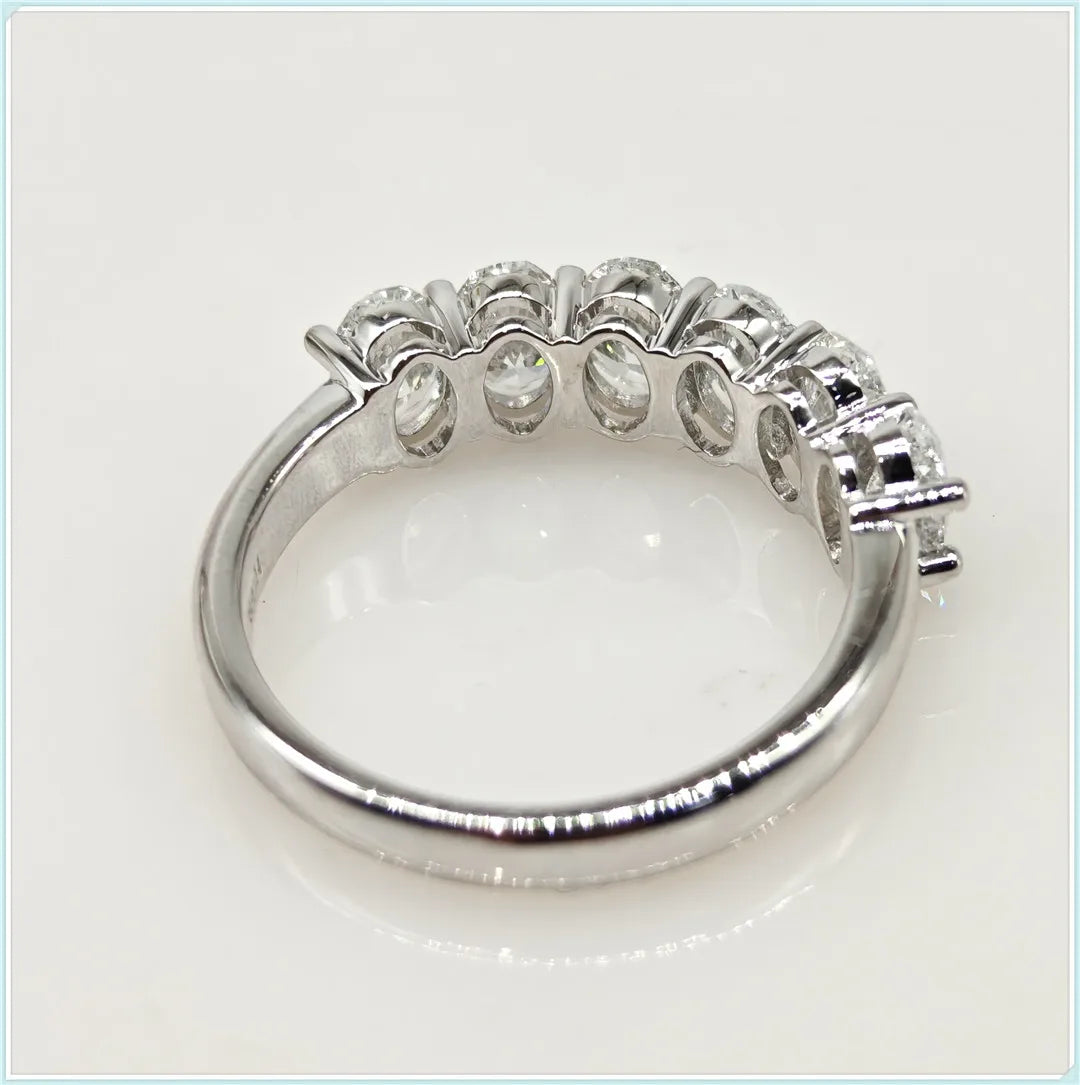Silver ring with embedded stones on a light gray background