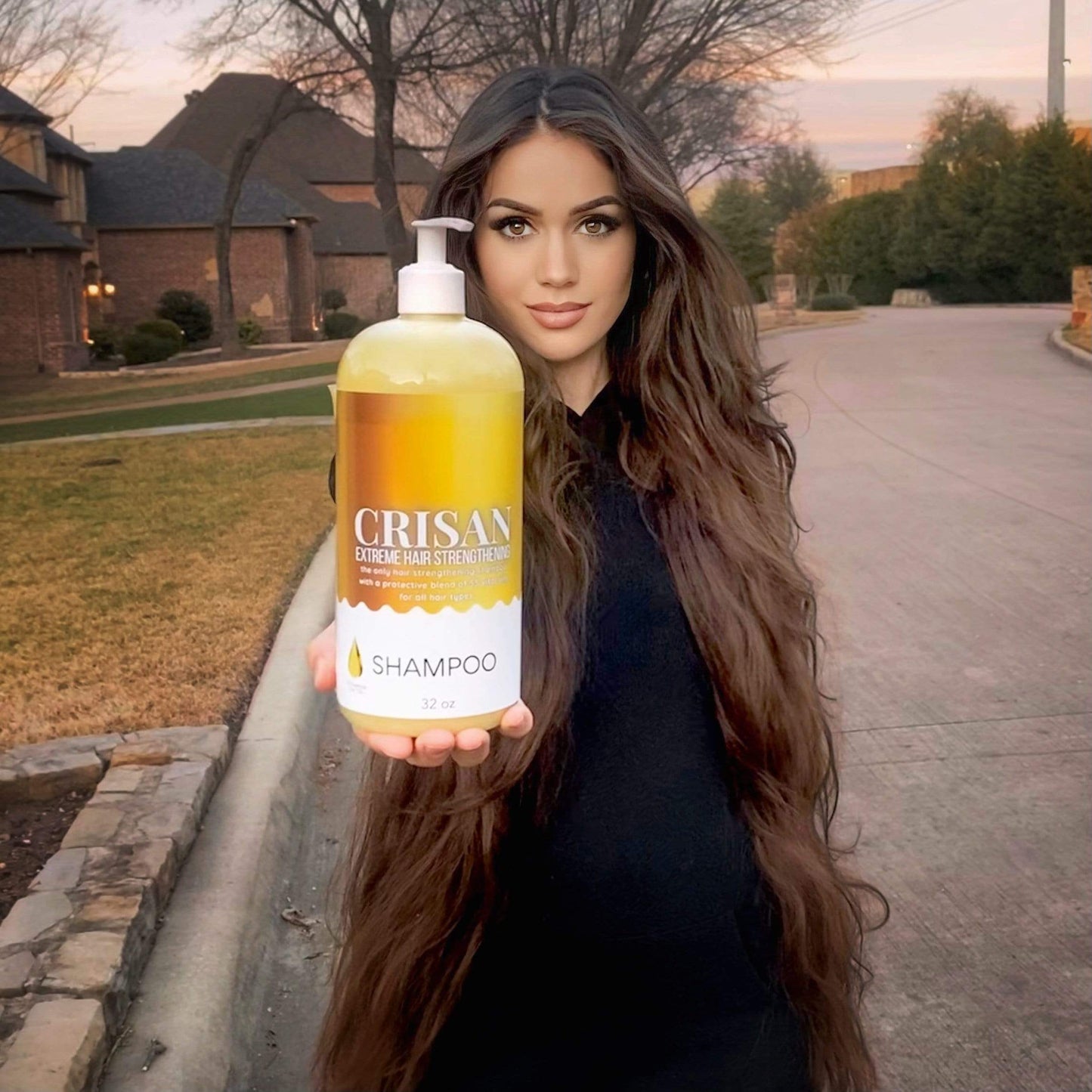 Woman holding a bottle of Crisan shampoo outdoors.