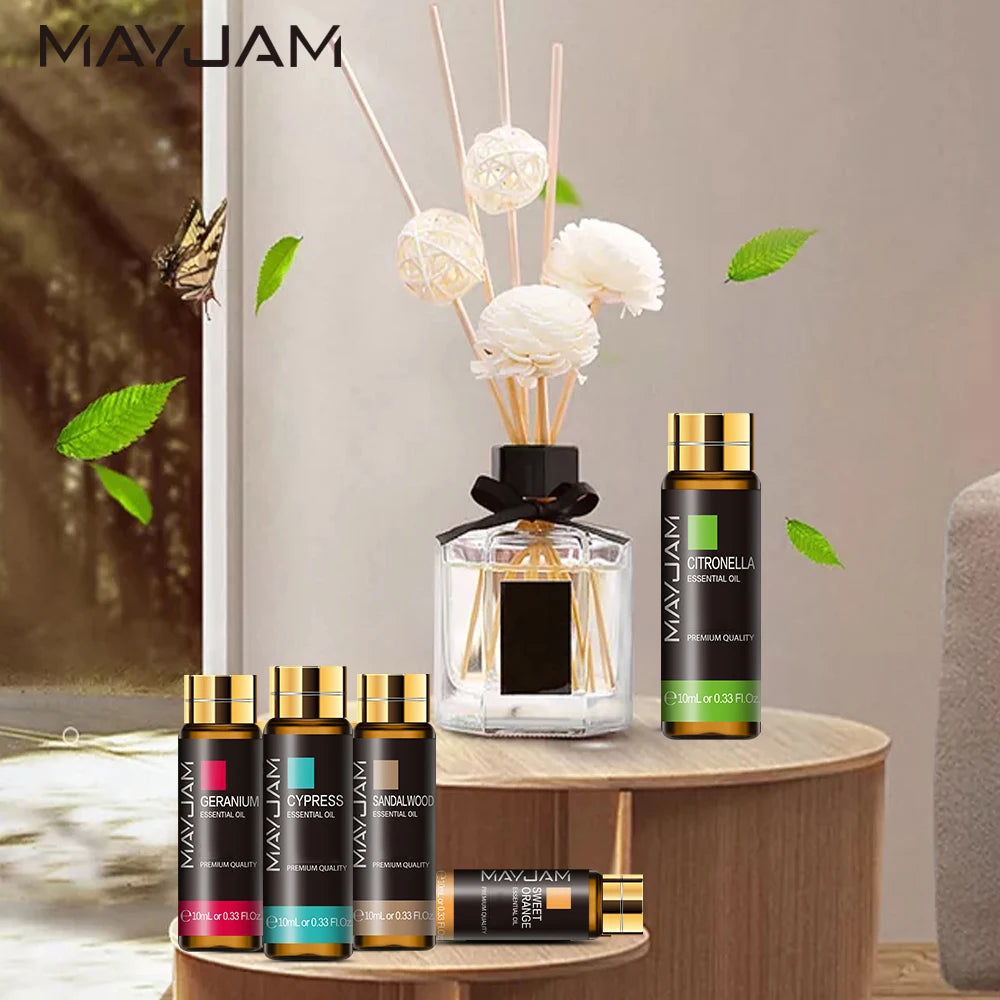 MayJam essential oil bottles and diffuser on a wooden table with decorative elements.