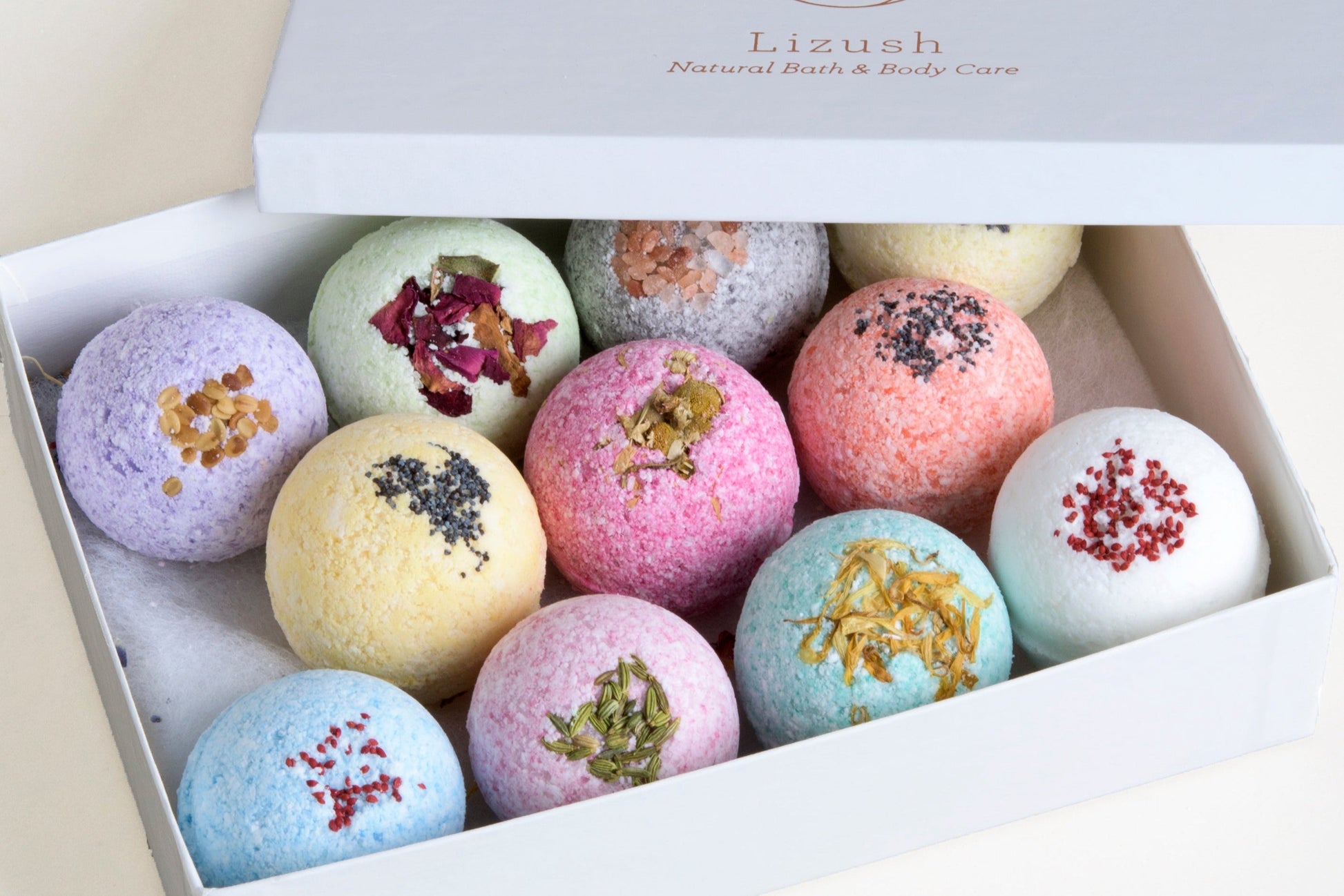 Box of colorful bath bombs with decorative elements on a light background