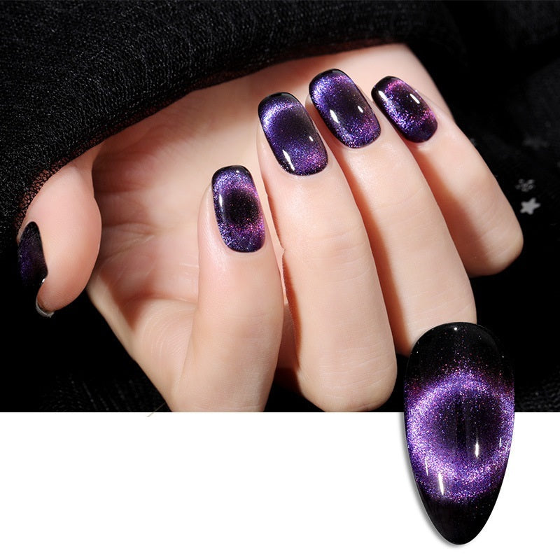 Close-up of a hand showcasing elegant, glittery cat-eye nail polish with a luminous purple shimmer, set against a sleek black background.