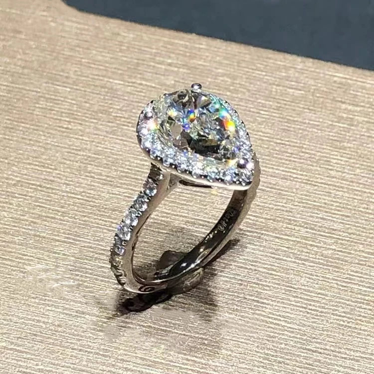 14K White Gold with a large diamond and smaller diamonds on a textured surface Ring with a pink gemstone and diamond accents on a textured surface Ring with a yellow gemstone and diamond accents on a textured surface 14k Gold 3.5ct Moissanite Jewelry Diamond Ring A bold, architectural silhouette with a “camera-flash” kind of brilliance. 