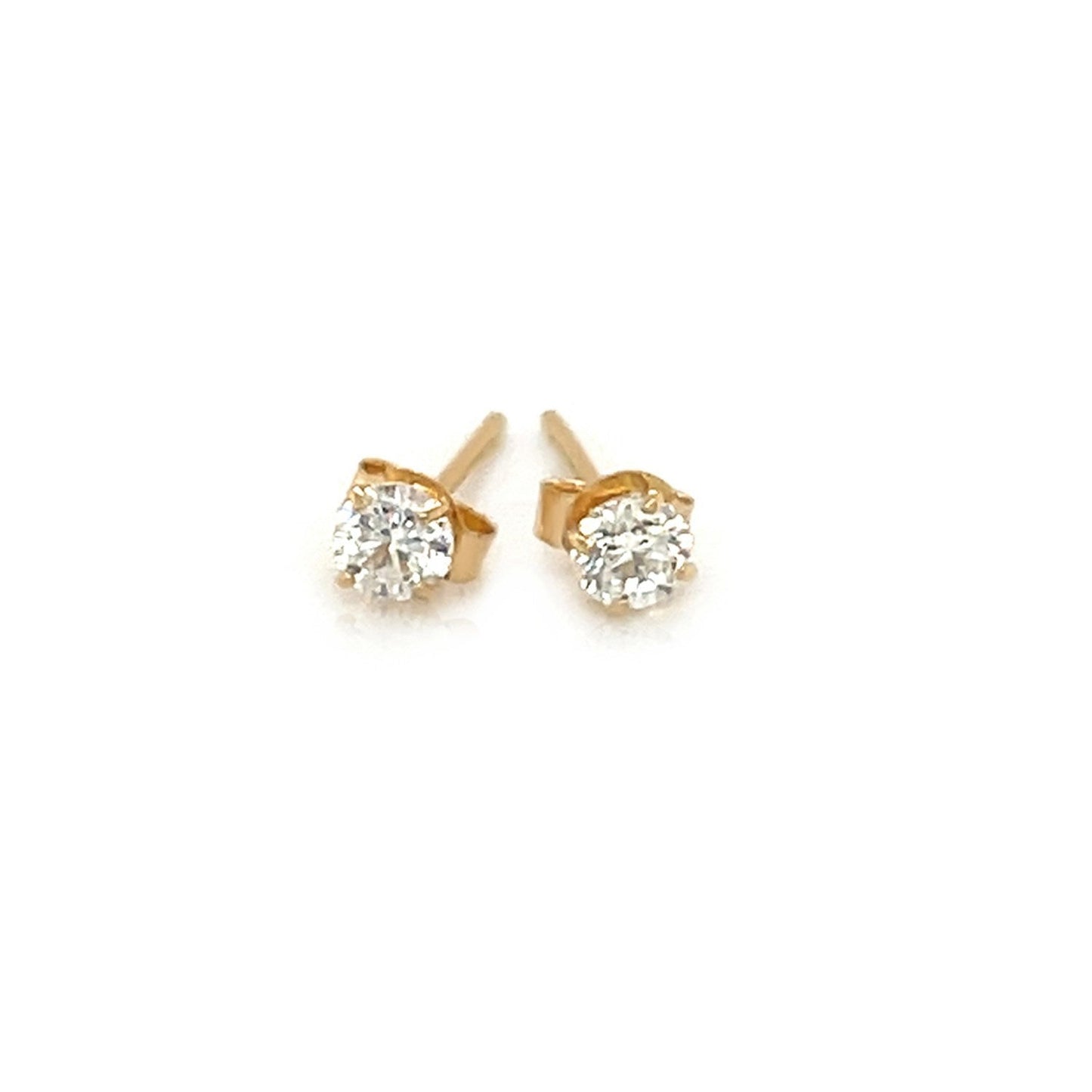 Pair of gold stud earrings with clear gemstones on a white background
