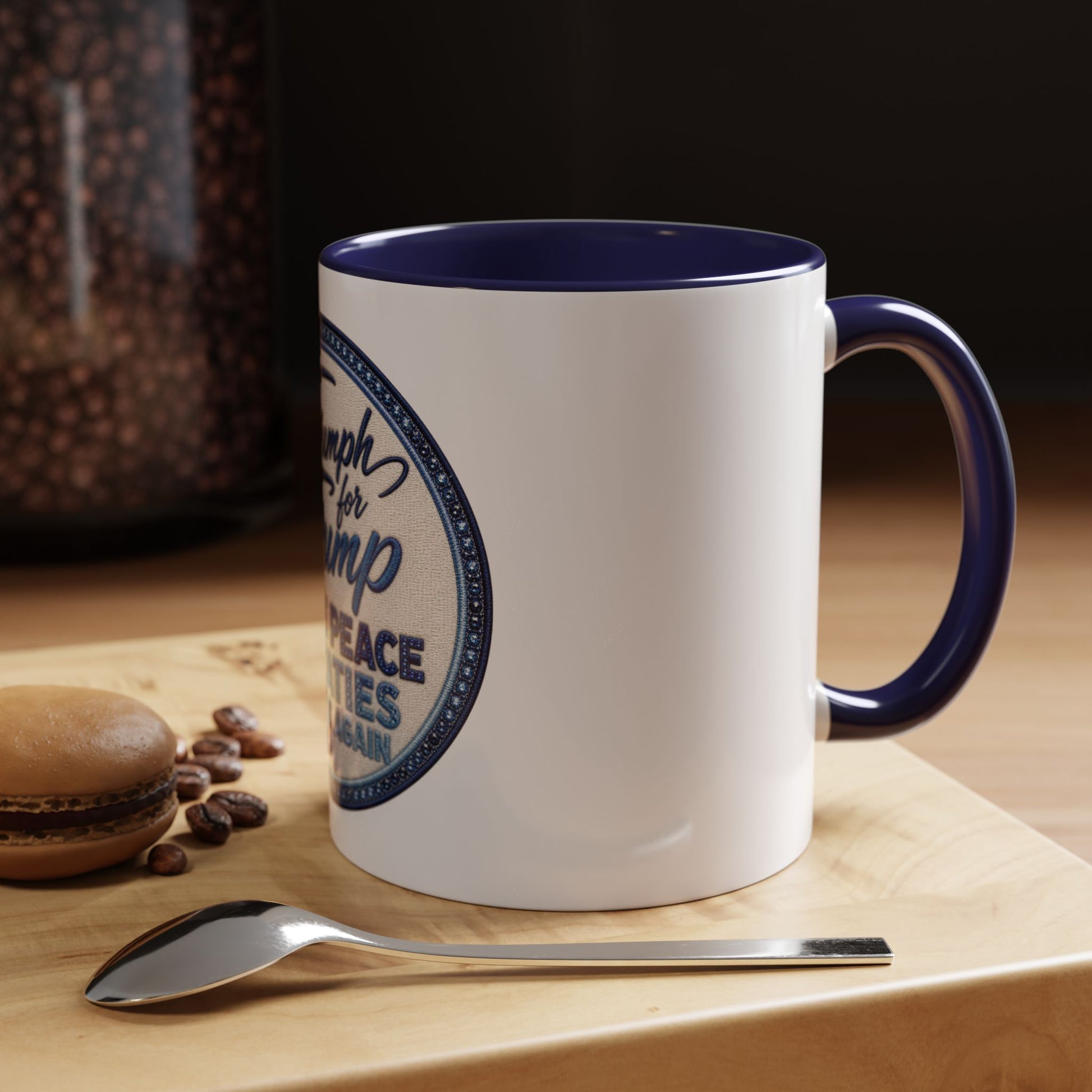 White mug with blue interior and handle, featuring a circular design, on a wooden surface with coffee beans and a spoon. Donald Trump patriotic coffee cup with embroidered-style circular badge artwork for coffee and tea lovers.