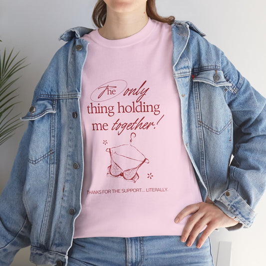 Person wearing a pink t-shirt with text and a denim jacket. "Holding It Together" Unisex Heavy Cotton Tee: Funny Gift for Friends, Family, Self-Care, Casual Wear, Humor Shirts, Gift for Her