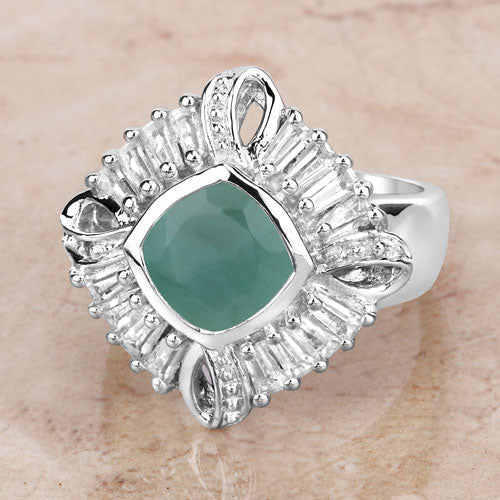 Silver ring with a green gemstone and diamond-like accents on a beige background
