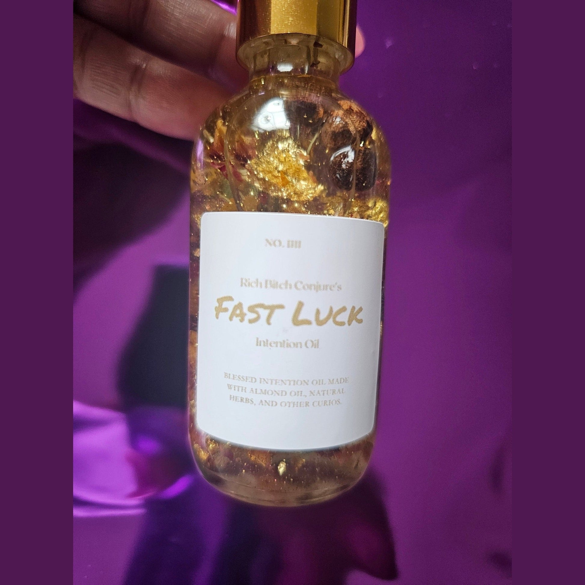 Bottle of 'Fast Luck' oil with a gold cap against a purple background. Rich Bitch Conjure's Fast Luck Money Oil