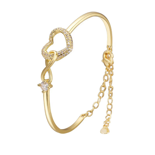 Gold infinity heart bracelet for daughter with sparkling zircon accents, adjustable chain, elegant gold bangle, symbolic love gift, Valentine's Day jewelry, birthday gift for teen daughter, women's fashion bracelet on white background.