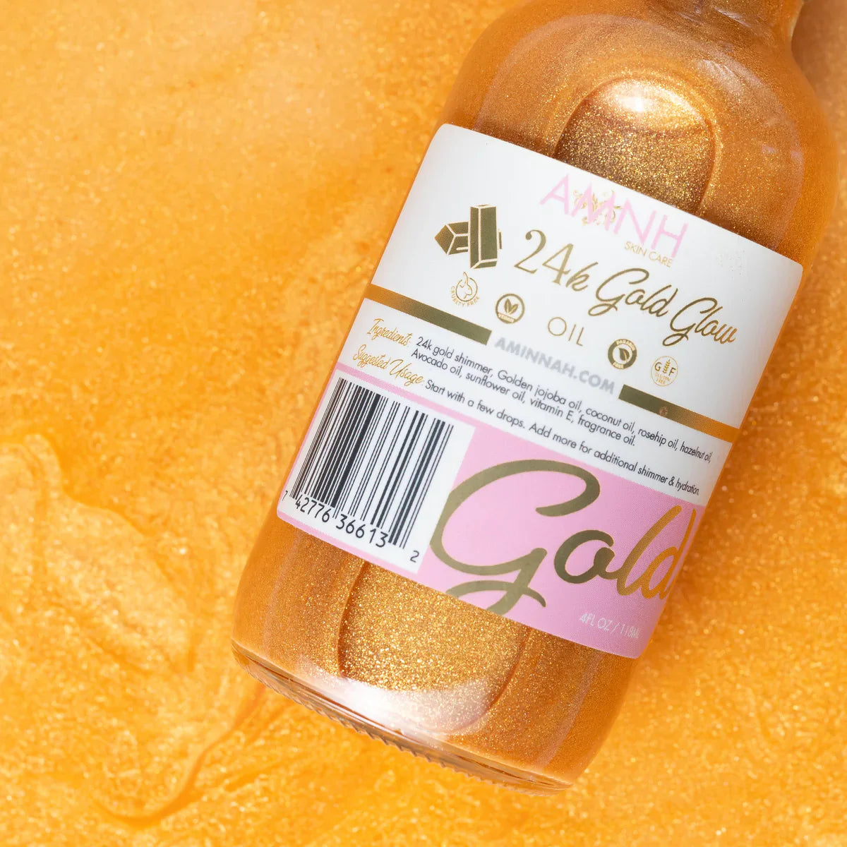 24K Gold Glow Body Oil bottle featuring shimmering gold-infused moisturizing oil by AMINNAH Skincare on a radiant gold background. Hydrating body oil with 24K gold shimmer, jojoba oil, coconut oil, avocado oil, vitamin E, and fragrance oil for glowing, radiant skin.