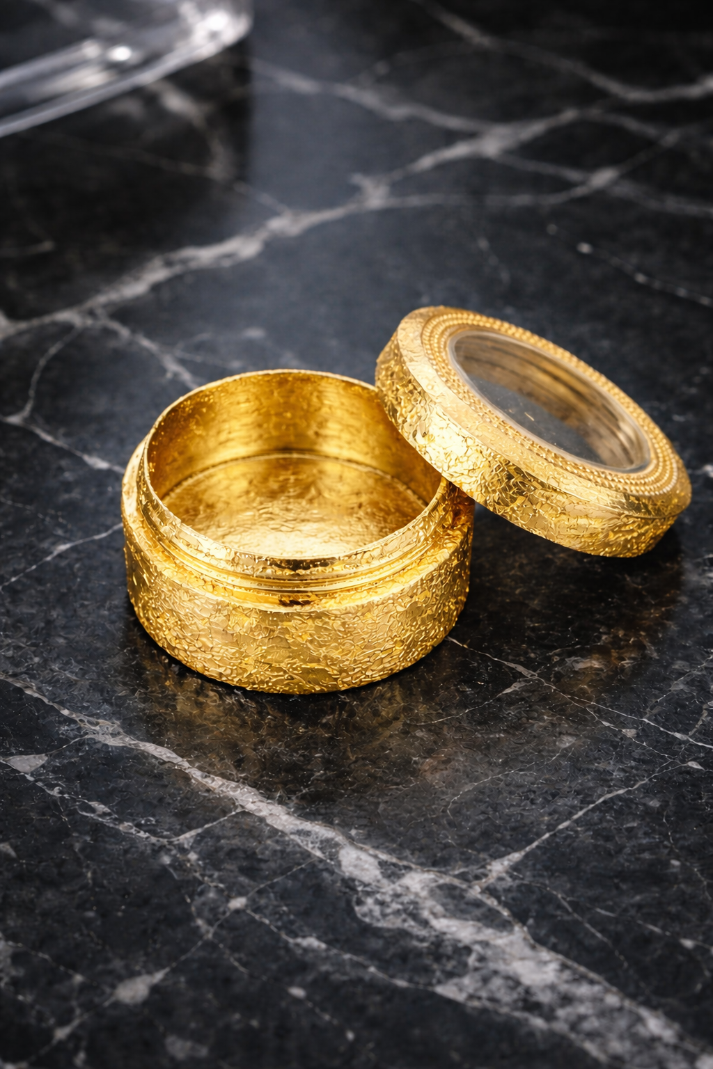 24K gold flake container dark marble surface 24K gold flake container dark marble surface