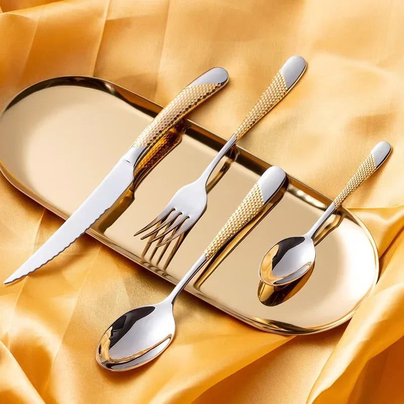 Set of gold-handled cutlery on a yellow fabric background