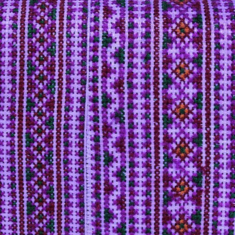 Close-up of a fabric with intricate purple and green pattern