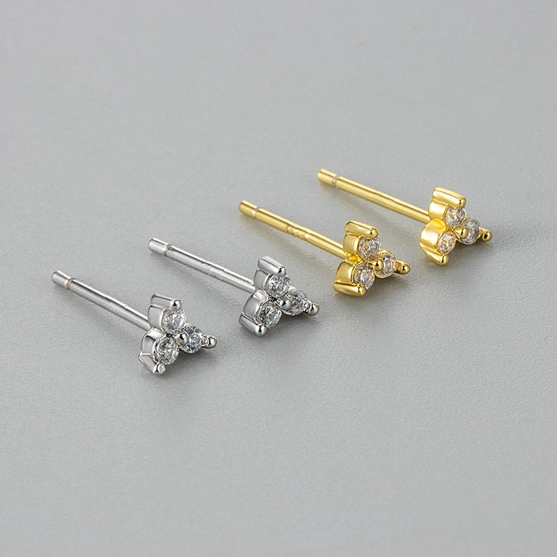 Pair of gold and silver butterfly-shaped earrings on a gray background