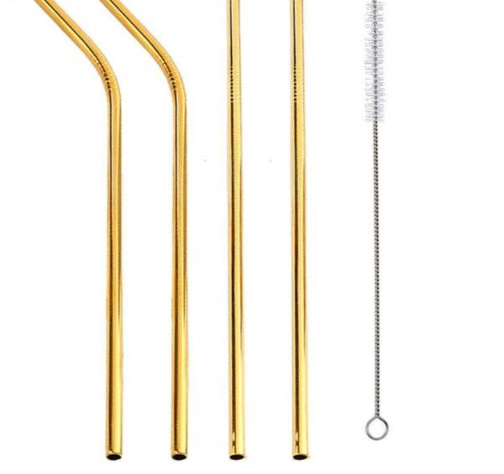 Set of gold metal straws and cleaning brush on a white background