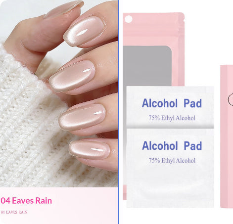 A close-up of manicured fingernails wearing a glossy pale pink nail polish labeled '04 Eaves Rain,' shown beside product packaging including a pink pouch and two white alcohol pad packets labeled '75% Ethyl Alcohol.'.