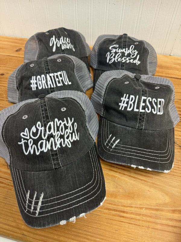 5-pack of black and gray distressed mesh trucker hats with embroidered inspirational sayings including "Grateful," "Simply Blessed," "#Blessed," and "Crazy Thankful," displayed on a wooden tabletop. 5-Pack Gratitude Embroidered Mesh Trucker Hats – Adjustable Cotton Baseball Caps for Men & Women, One Size Fits Most, Bulk Gift Set