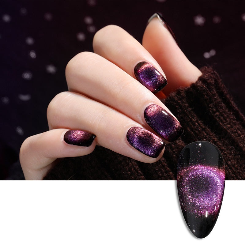 Elegant close-up of a hand showcasing a deep purple and black gradient cat eye nail polish, featuring a shimmering magnetic effect against a dark, moody background.