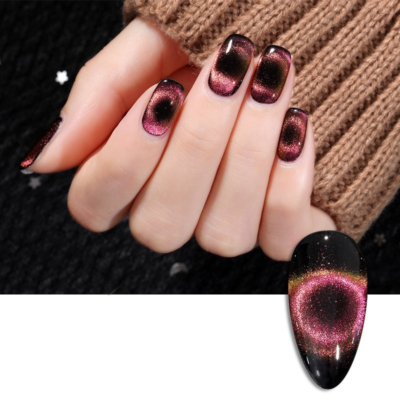 Stunning close-up of a hand showcasing a professional black and pink gradient cat-eye nail art design, set against a dark background to highlight the magnetic, shimmering finish.