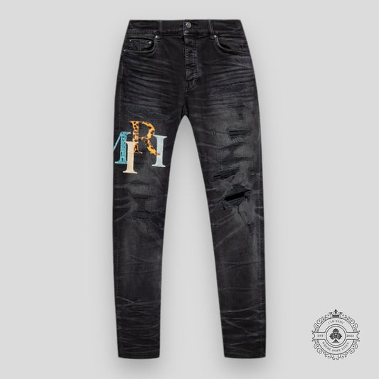 Amiri Staggered Logo Denim Jeans in Black