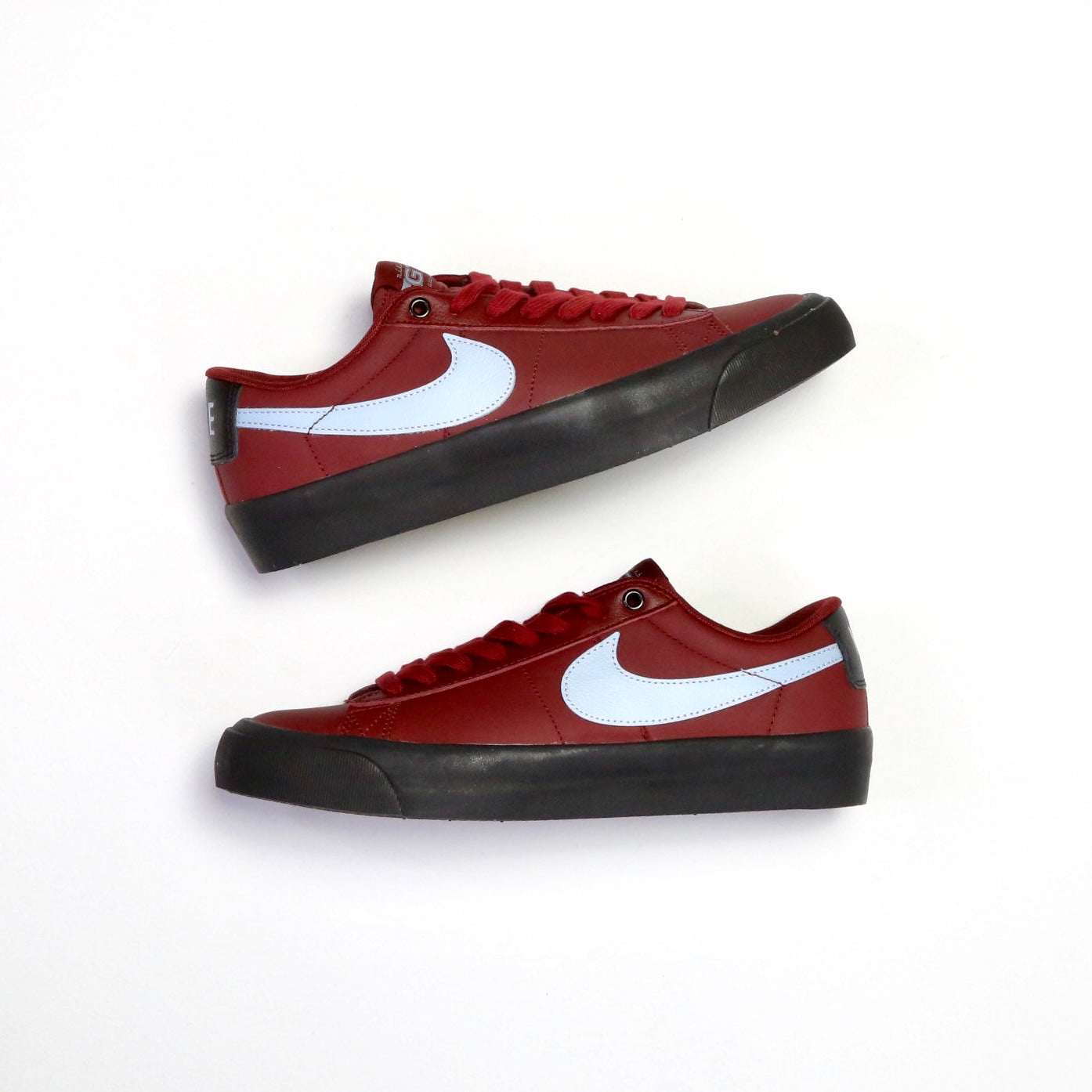 A pair of Nike low-top sneakers in red with a white Swoosh and black rubber soles, displayed on a clean white background. Nike SB Blazer Low Pro GT DV1226-600