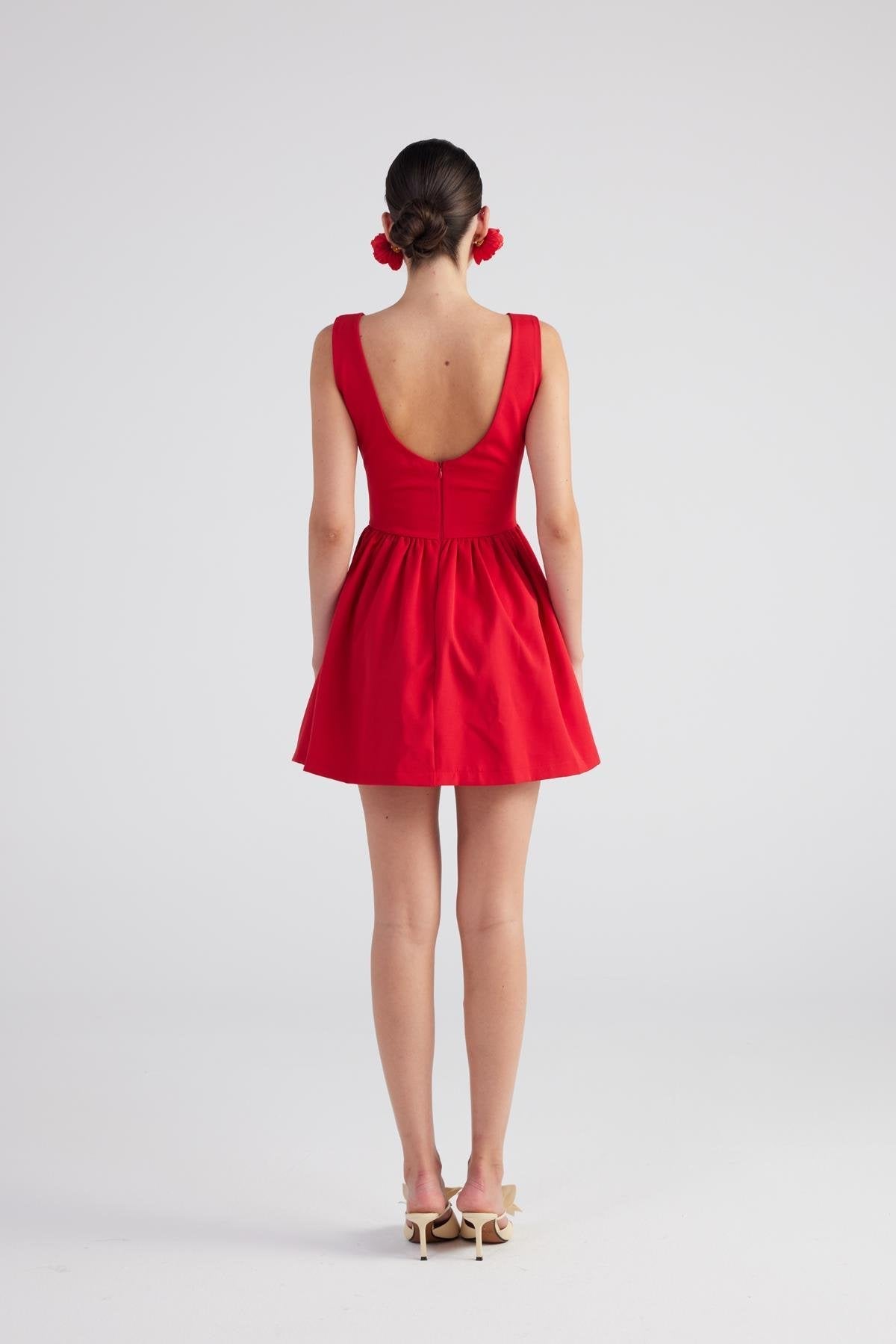Red dress with open back worn by a person on a white background