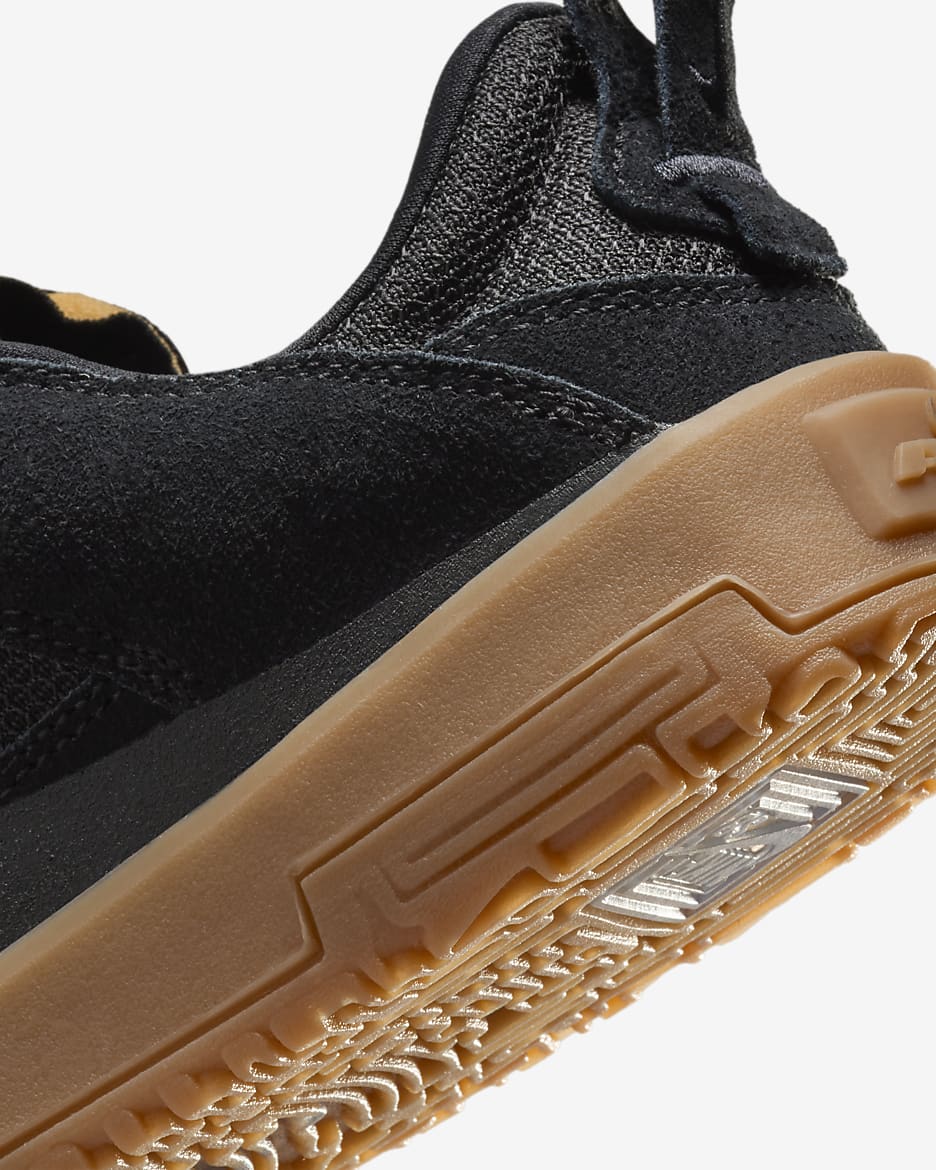 Close-up of a black sneaker showing the side profile, black mesh and suede upper, and a thick tan gum rubber sole against a light gray background. Nike SB Day One - Youth - FN4210-001