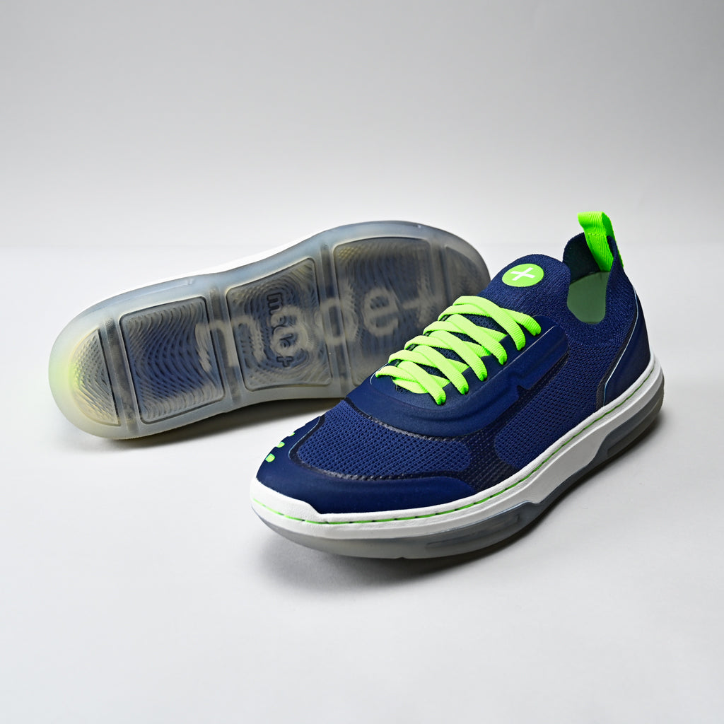 Blue sneaker with green laces on a white background