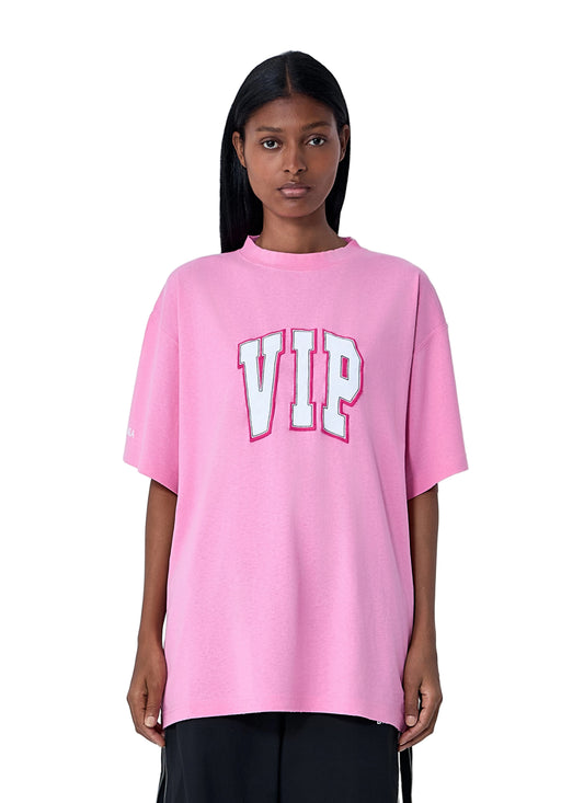 Person wearing a pink 'VIP' t-shirt against a white background