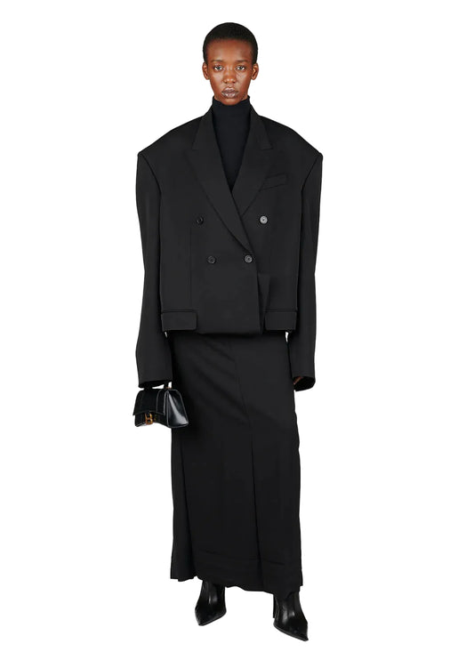 Person wearing a black suit with a white background
