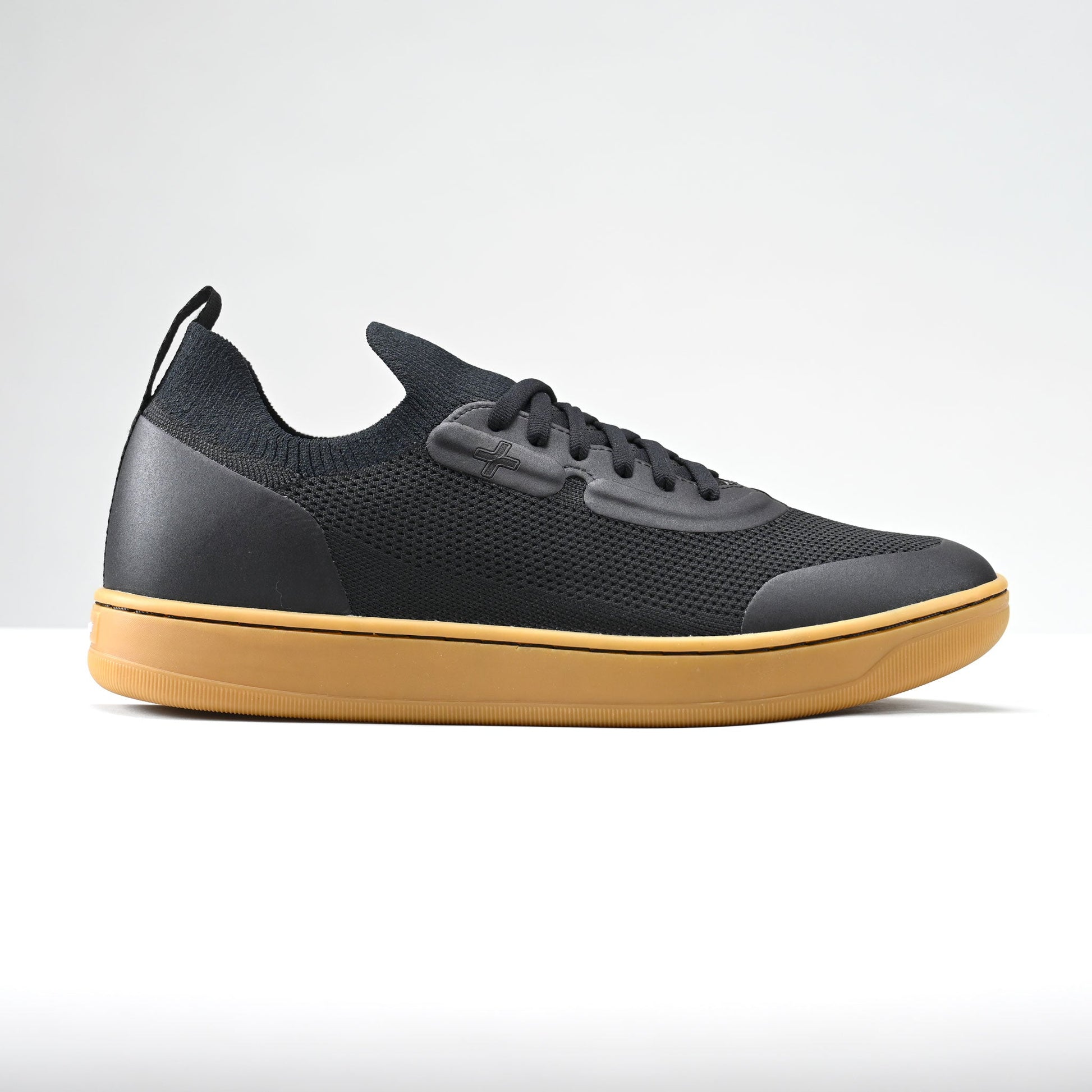 Black sneaker with a yellow sole on a white background