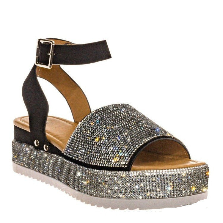 Black sandal with rhinestone embellishments on a white background