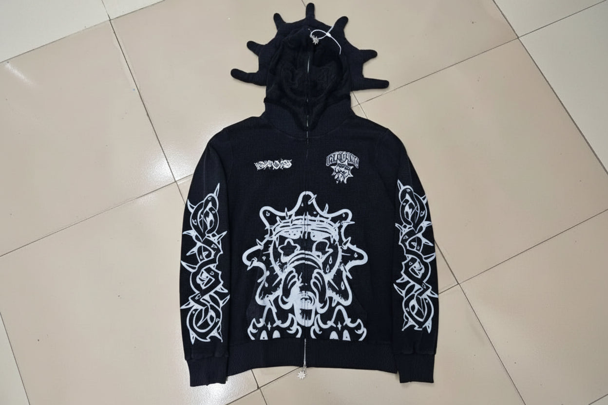 Black hoodie with white graphics and text on a tiled floor