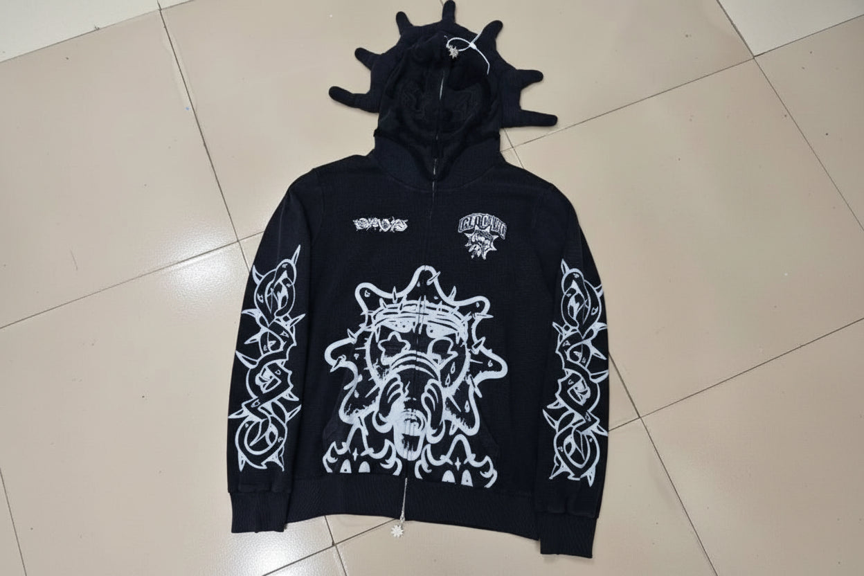 Black hoodie with white graphics and text on a tiled floor