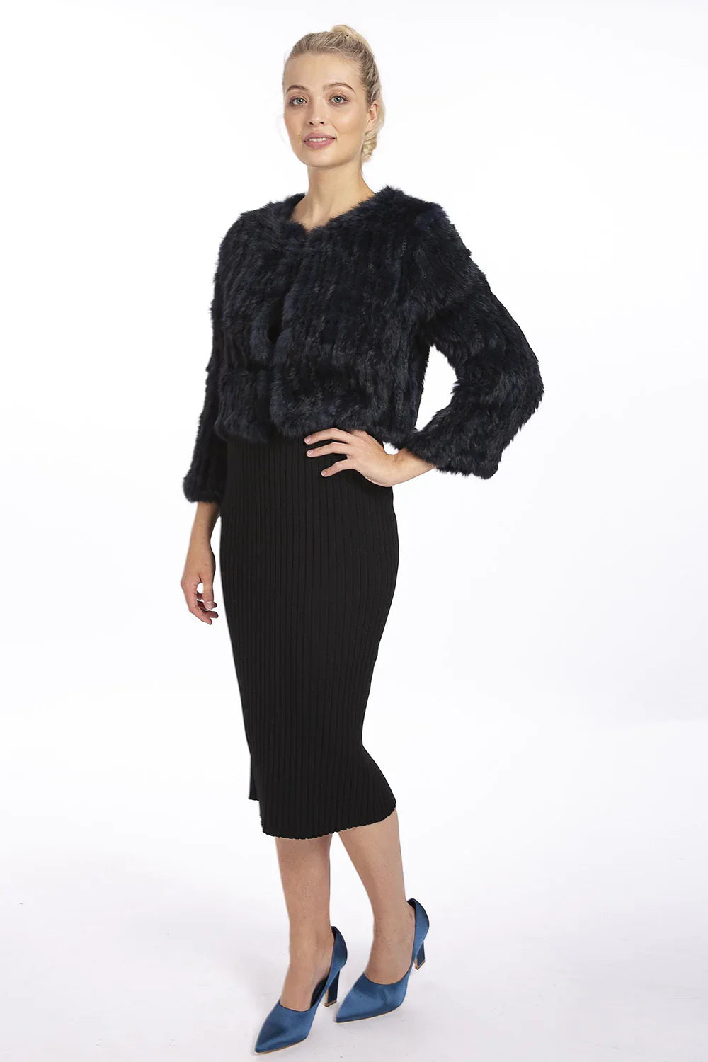 Woman wearing a black fur jacket and black pencil skirt on a white background