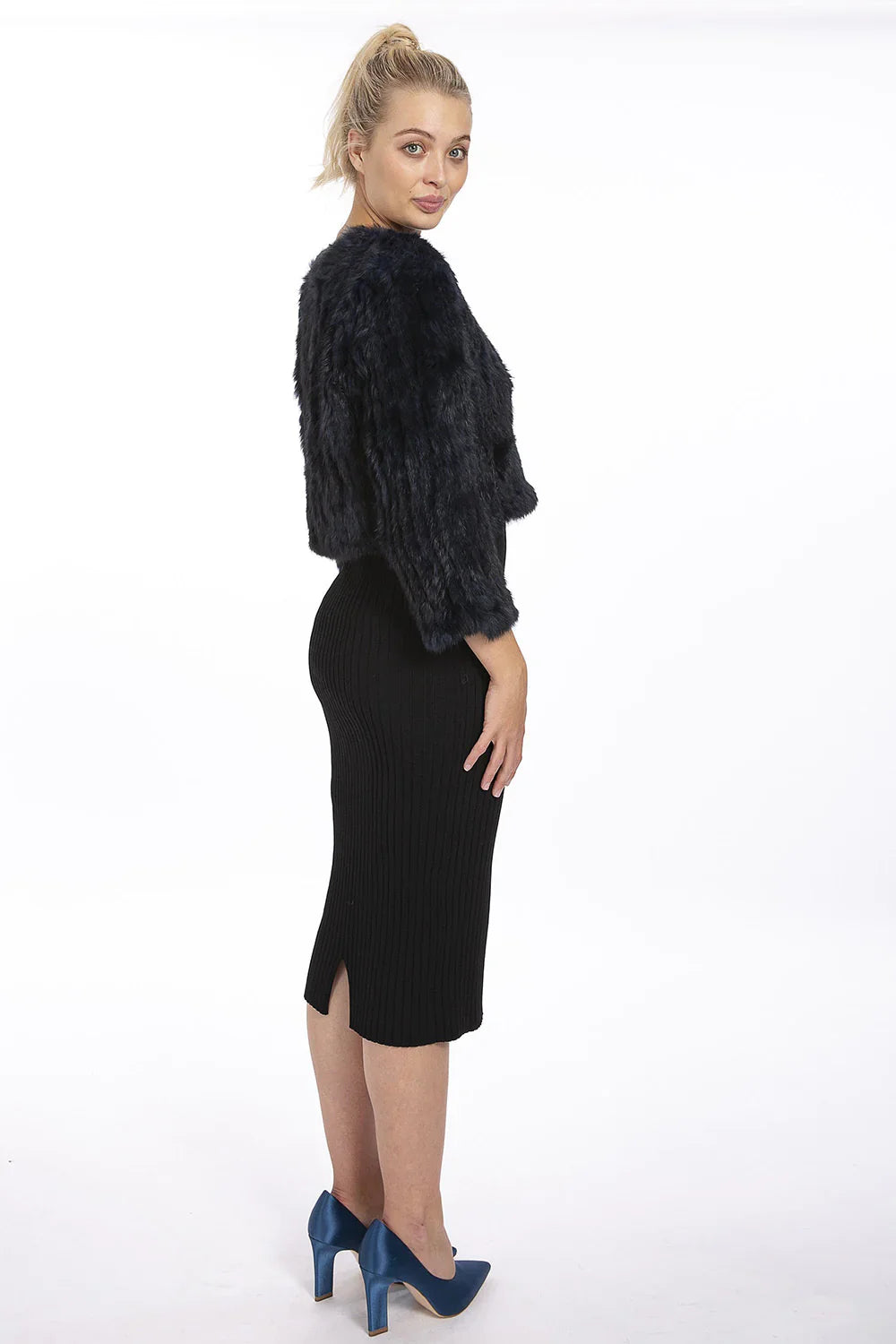 Woman wearing a black fur jacket and black skirt on a white background