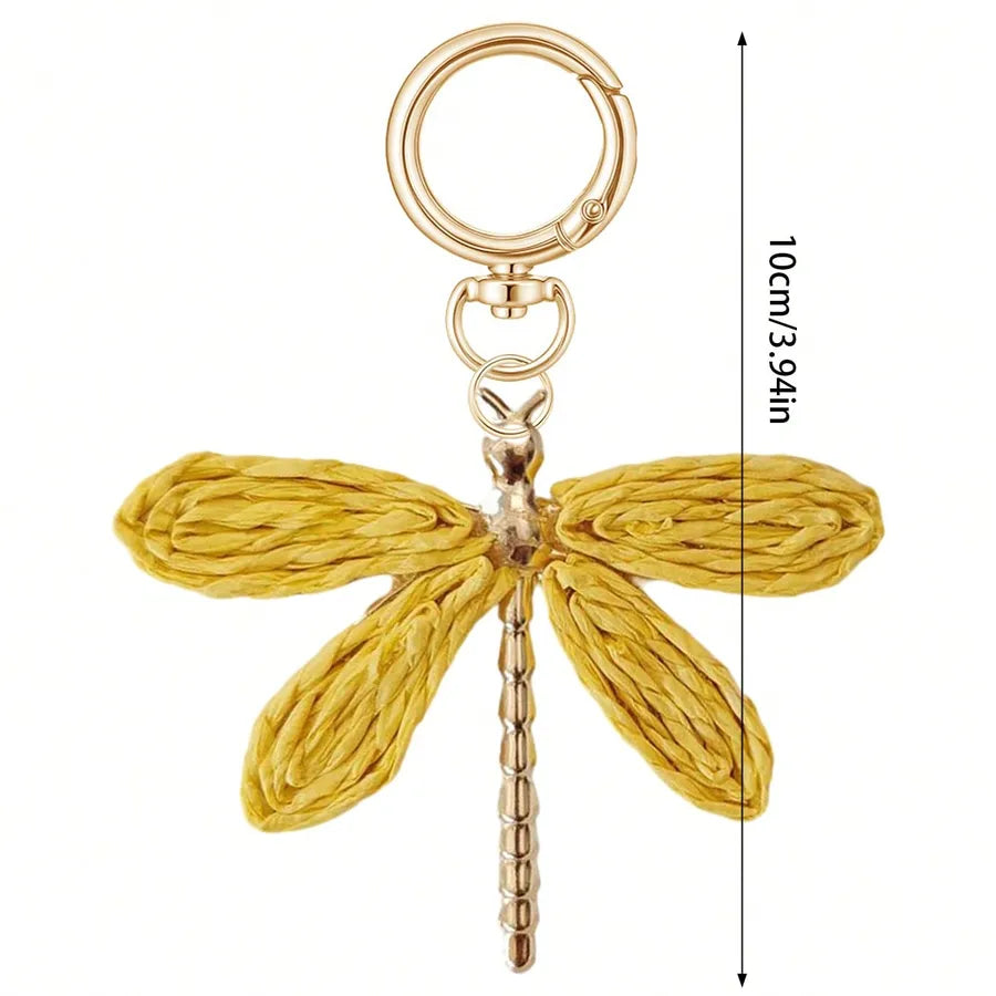 Gold dragonfly bag charm with textured alloy wings, gold-tone keyring and clasp, shown on a white background with a 10 cm (3.94 in) size reference. Decorative bohemian keychain accessory for handbags, purses, backpacks, and totes.