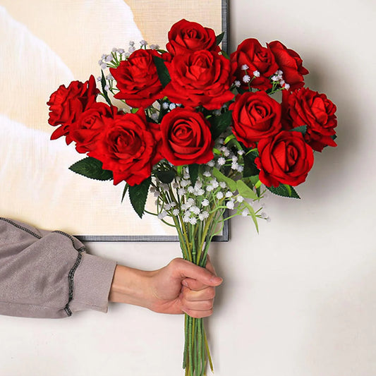 Bouquet of red roses held by a person with a neutral background