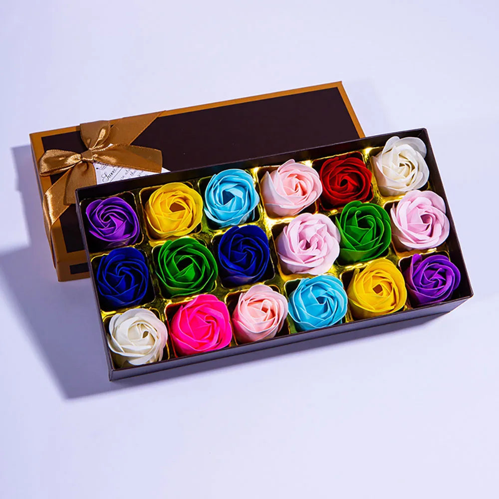 Box of colorful soap roses with a gold bow on a light purple background